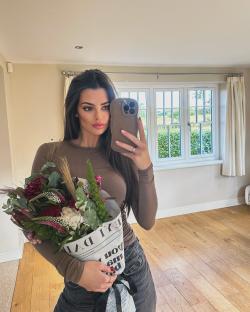 Emma McVey holding a bouquet of flowers and taking a selfie.