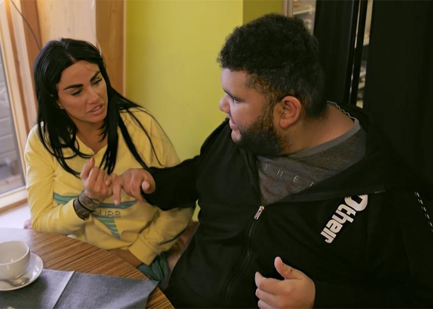 Katie Price and her son Harvey sitting together outdoors.