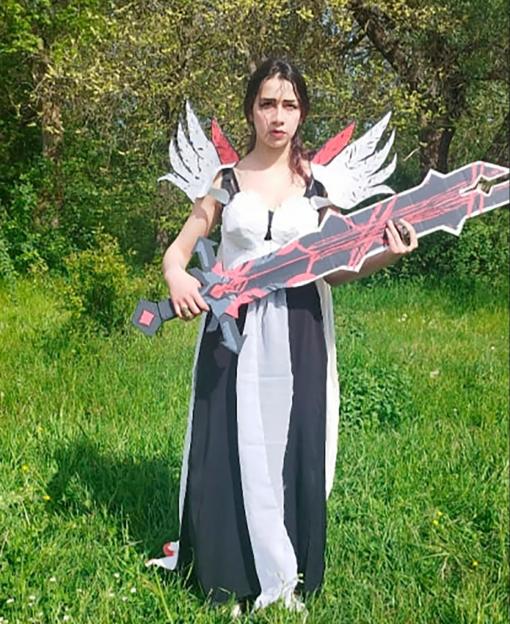 Woman in cosplay holding a large sword.