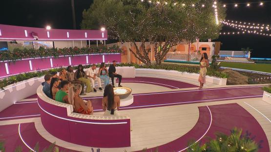 Islanders gathered around a fire pit during a Love Island episode.