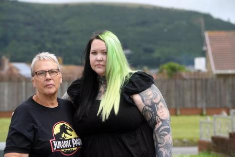 A Welsh mother and daughter stand outside their home.