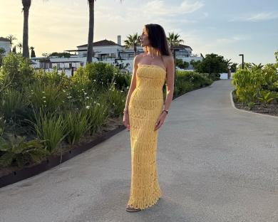 Woman in yellow dress at resort.
