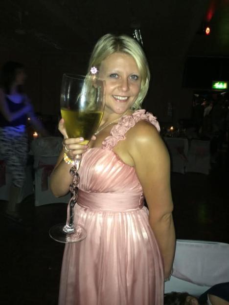 Woman in pink dress holding a large glass of champagne.