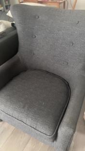 Grey armchair with button tufting.