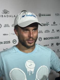 Man wearing an OnlyFans hat and light blue tennis shirt.