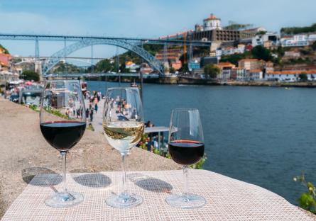 Three glasses of wine overlooking the Douro River in Porto, Portugal.