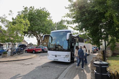 Tourists disembarking a tour bus in Bampton, Oxfordshire.
