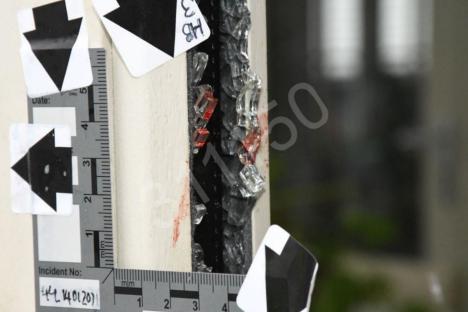 Crime scene photo: blood and broken glass on a door.