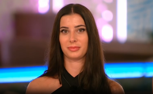 Woman with long brown hair looking at the camera.