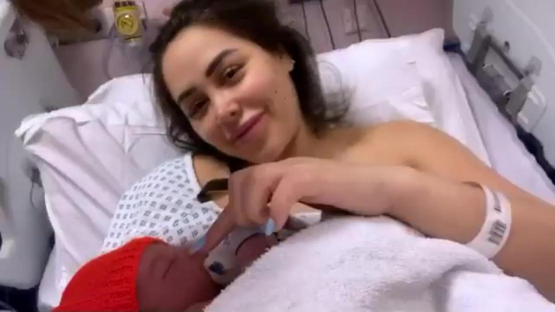 Marnie Simpson holding her newborn baby in a hospital bed.