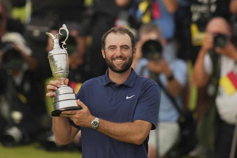 Scottie Scheffler holding the Claret Jug trophy.