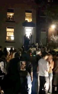 Large group of students at a noisy house party.