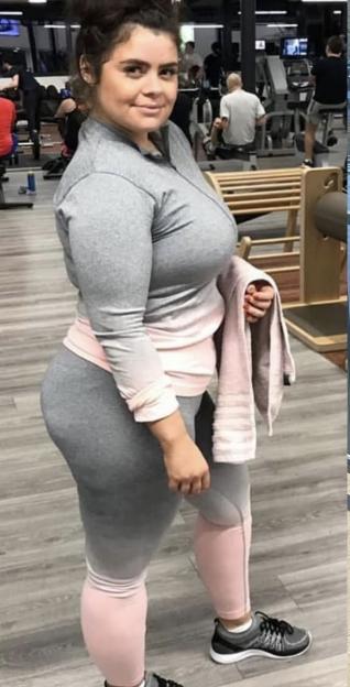Woman in a gym, holding a towel.