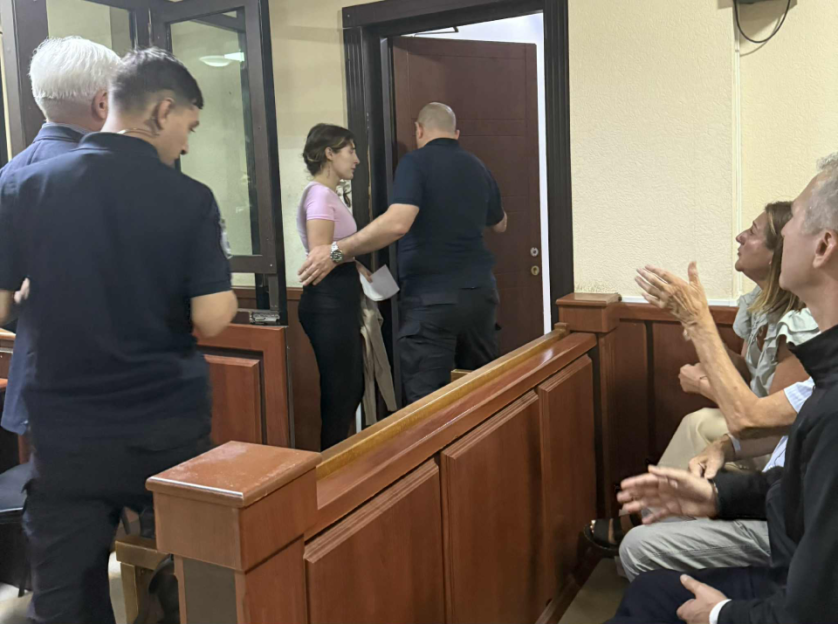 A woman escorted into a courtroom.