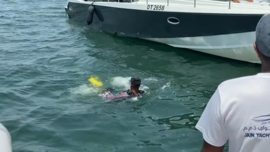 A diver in the water near a boat.