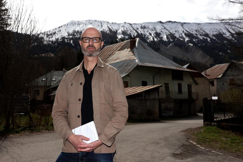 Man standing in front of a house in the French Alps.
