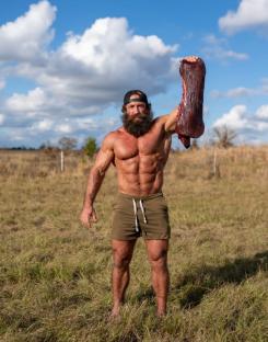 Muscular man holding a piece of liver.