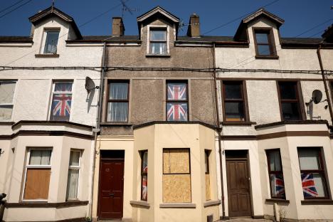 Buildings with boarded-up windows and Union Jack flags displayed in windows, following riots in Ballymena, Northern Ireland.