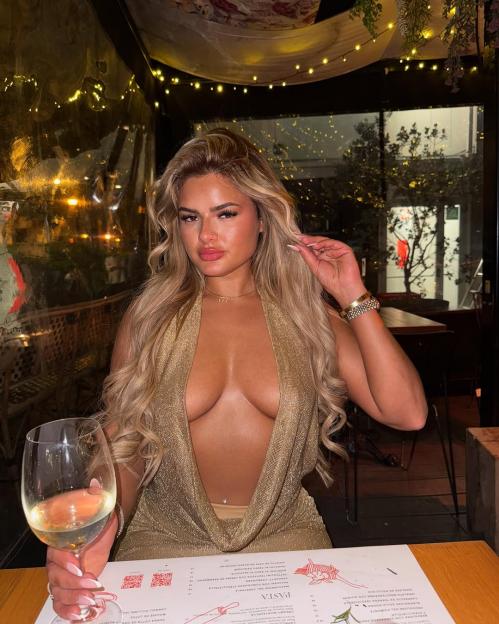 Woman in a low-cut gold top at a restaurant.
