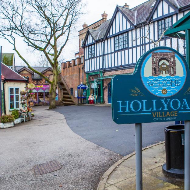 Welcome to Hollyoaks Village sign in front of the village set.
