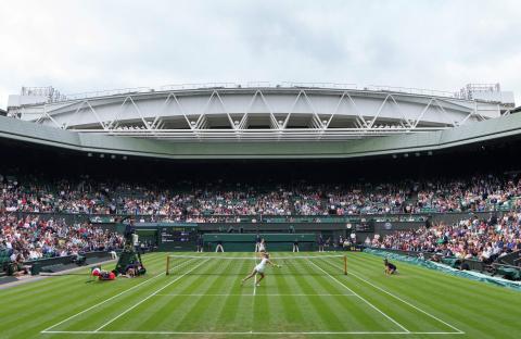 A tennis match in progress on Centre Court at Wimbledon.