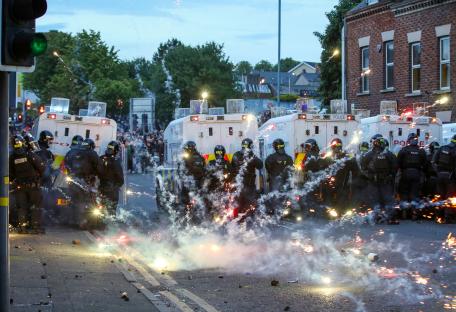Riot police in Northern Ireland facing fireworks thrown during anti-immigration demonstrations.
