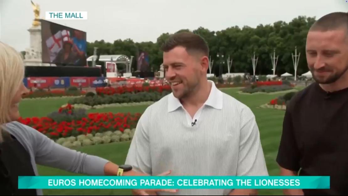 Jenni Falconer interviewing two men at the Euros homecoming parade.