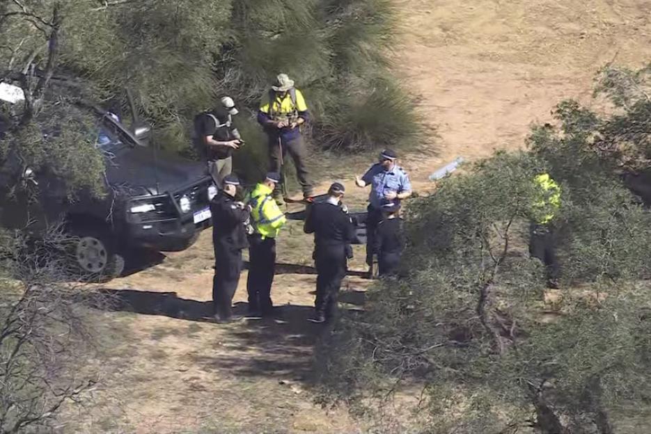 Police officers and investigators at a search scene.