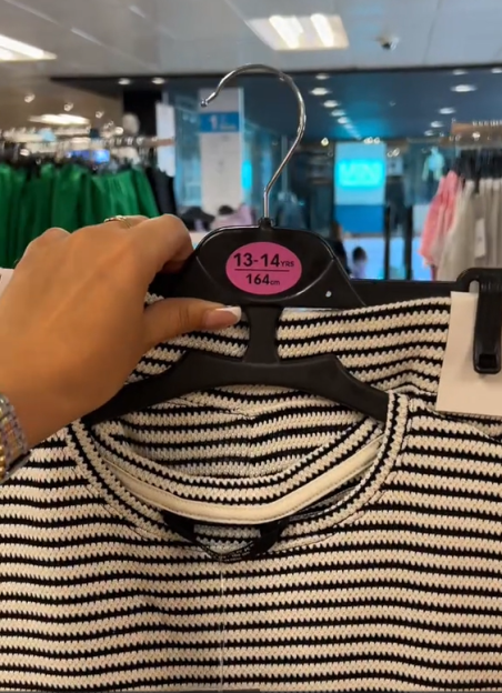 Black and white striped shirt on a hanger labeled size 13-14 years, 164 cm.