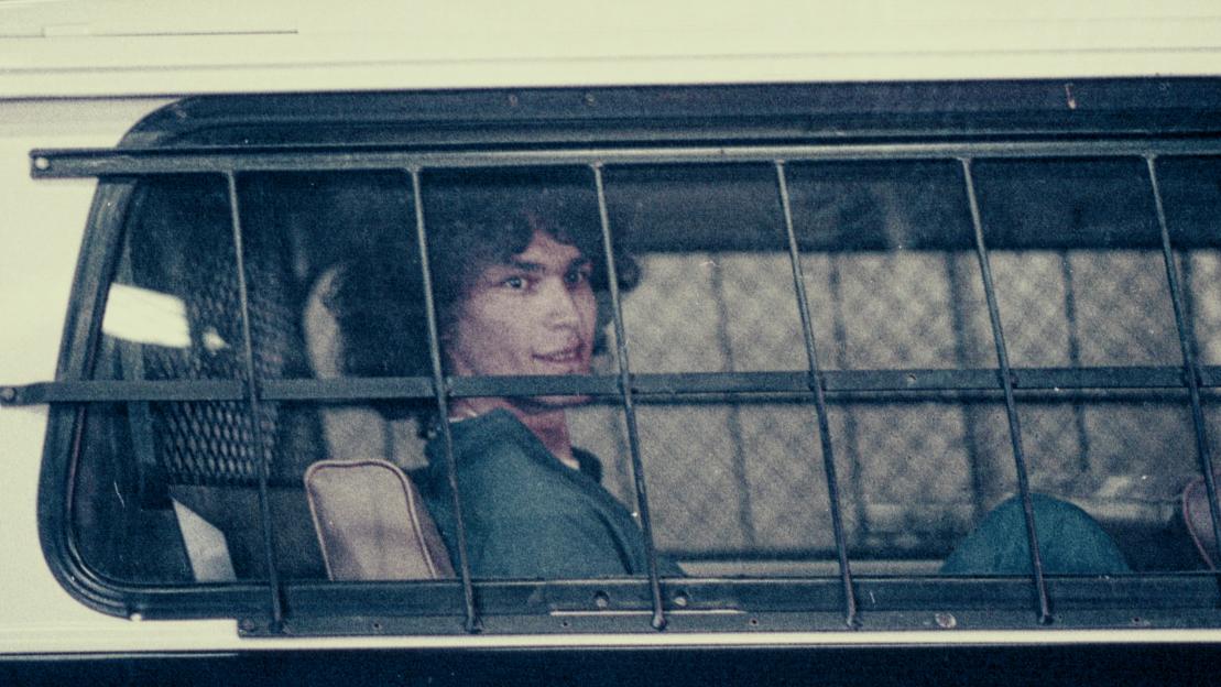 Richard Ramirez, the Night Stalker, seen through a cage in a police vehicle.