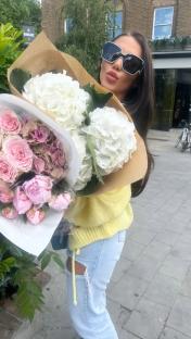 Woman holding a large bouquet of flowers.