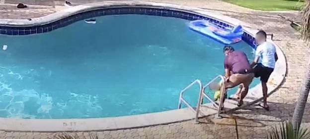 A man rescues a drowning boy from a swimming pool.