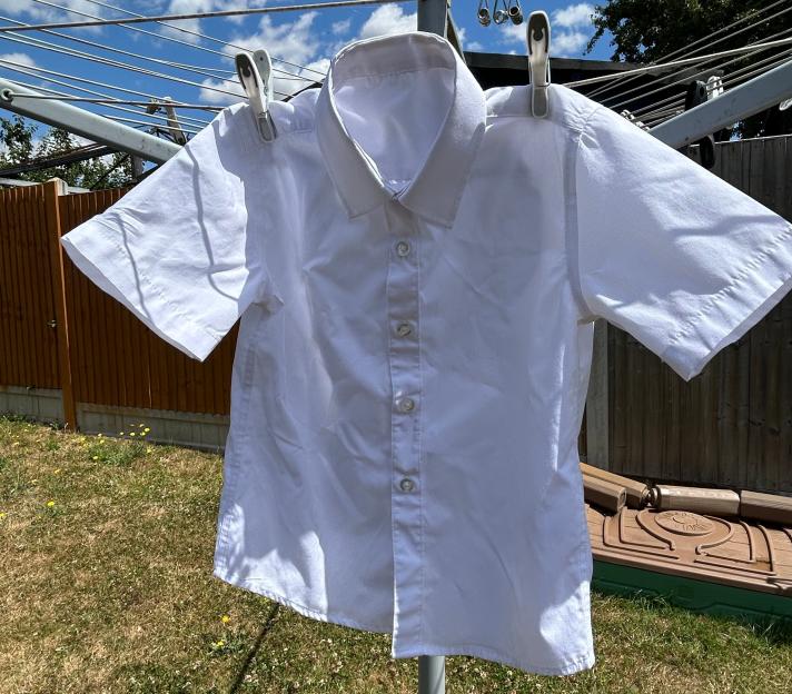 White short-sleeved shirt hanging on a clothesline.