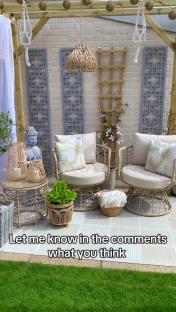 A renovated patio with wicker furniture, lanterns, and plants.
