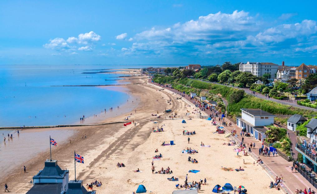Aerial view of a sandy beach with many tourists.