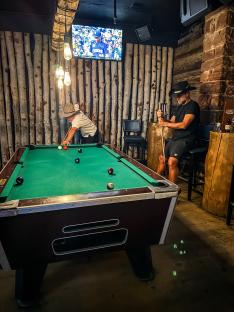 Two men playing pool in a bar.