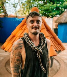 Man with tattoos and a snake around his neck in Ouidah, Benin.