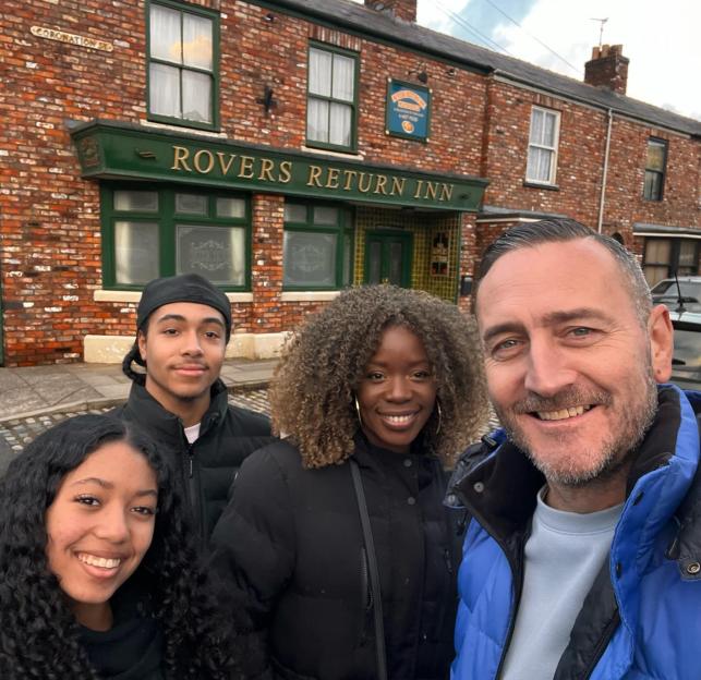 Will Mellor with his family in front of the Rovers Return Inn on the Coronation Street set.
