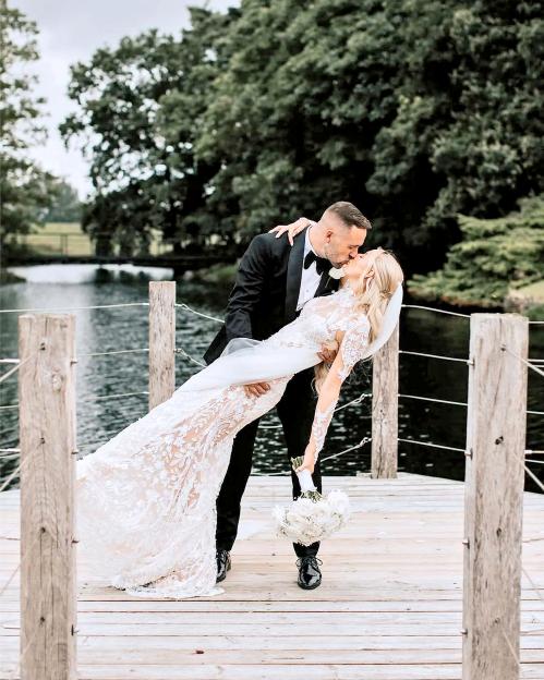 Bride and groom kissing on a dock.