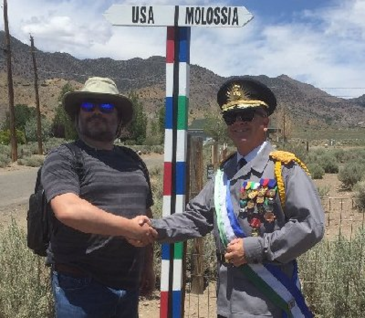 Photo of a man shaking hands with a Molossian official at the Molossia/USA border.
