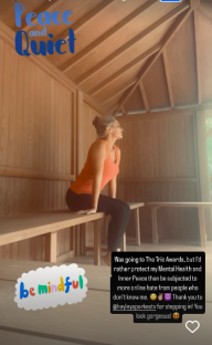 Woman sitting on a bench in a wooden structure, prioritizing mental health.