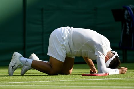 Sebastian Baez of Argentina on the ground during a Wimbledon tennis match.