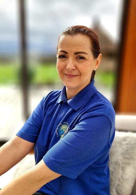 Portrait of a woman in a blue polo shirt.