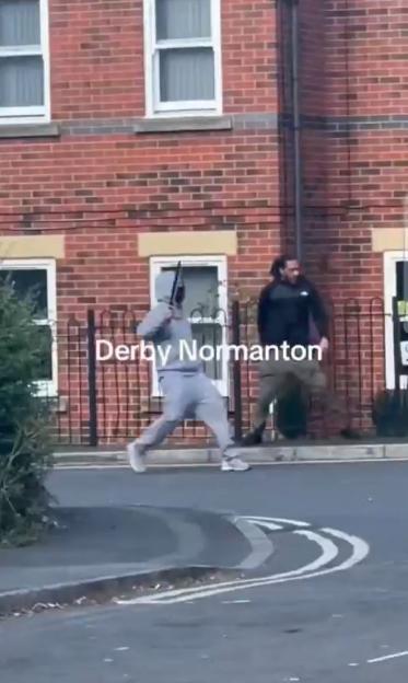 Two men on a street, one wielding a weapon.