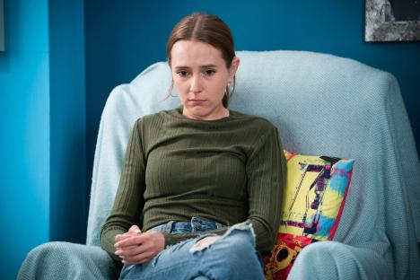 Frankie Lewis, from EastEnders, sits in a chair looking sad.