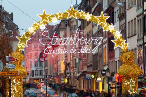 Strasbourg Christmas market entrance arch with lights and decorations.
