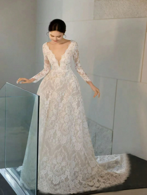 Woman in a long-sleeved lace wedding gown.