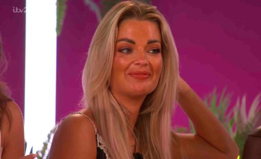 A blonde woman smiles on Love Island.