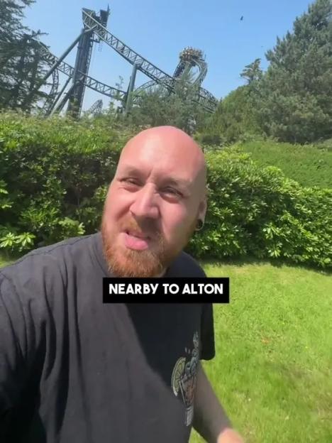 Man standing near Alton Towers rollercoaster.