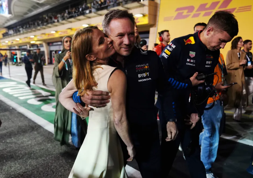 A man and woman embracing; the man is wearing a Red Bull Racing jacket.